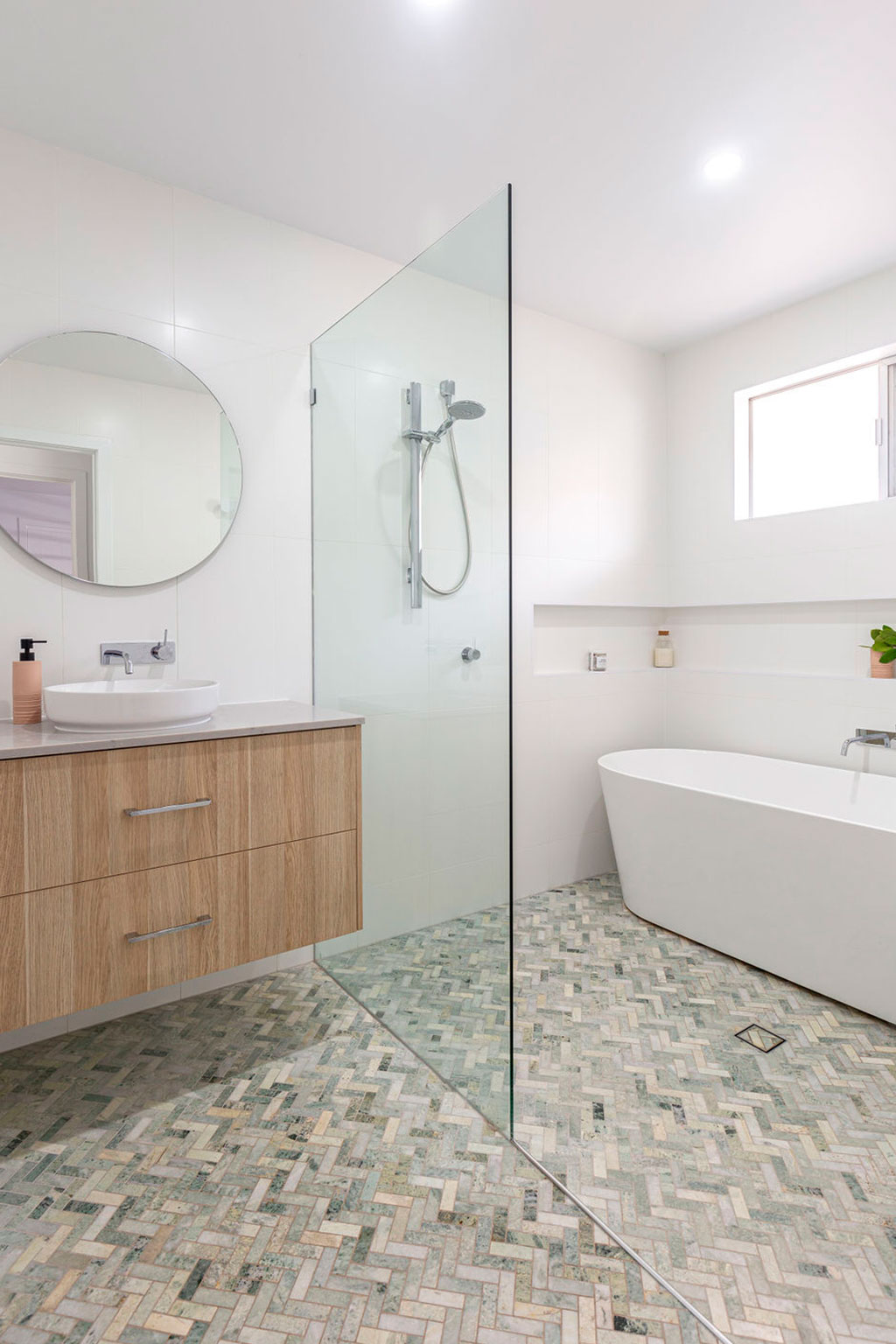 bathroom renovations - herringbone tiles - floating stone vanity - inset bathroom shelving - bathtub installation